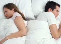 husband and wife in bed separated